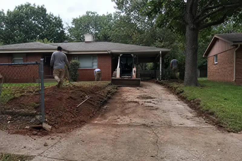 Narrow single-car 1950s concrete driveway at a small brick home in Midwest City, Oklahoma