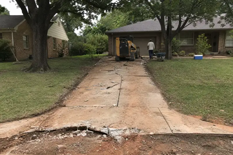 Narrow cracked driveway and apron at a 1960s ranch house in The Village, Oklahoma