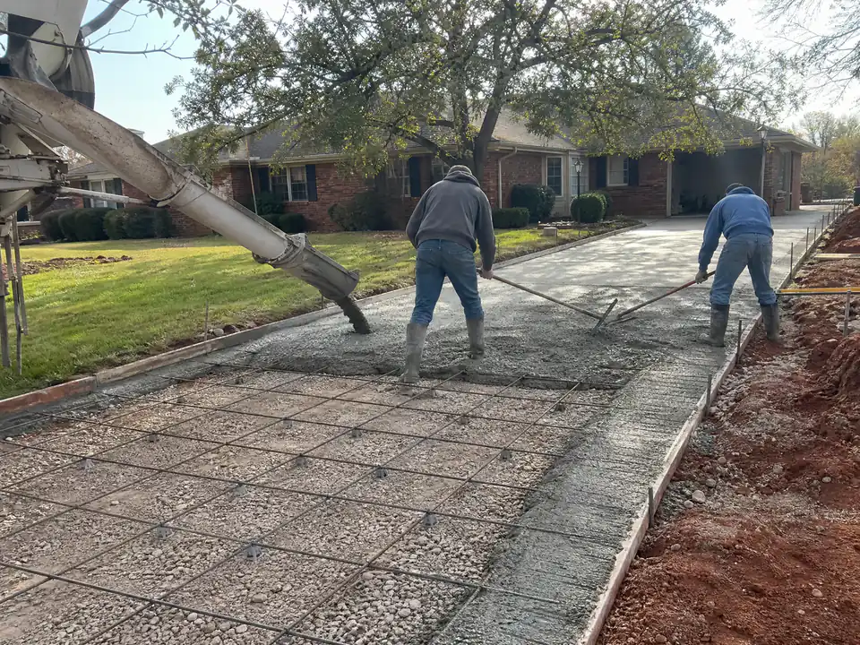 Ready-mix truck chute pouring air-entrained concrete over rebar into a formed driveway in Oklahoma City