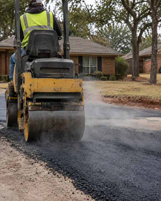 Rolling a hot asphalt patch flush with the driveway in Oklahoma City
