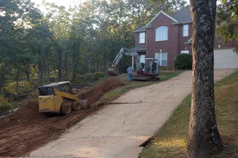 Sloped concrete driveway on a wooded hillside lot with post oaks in Edmond, Oklahoma